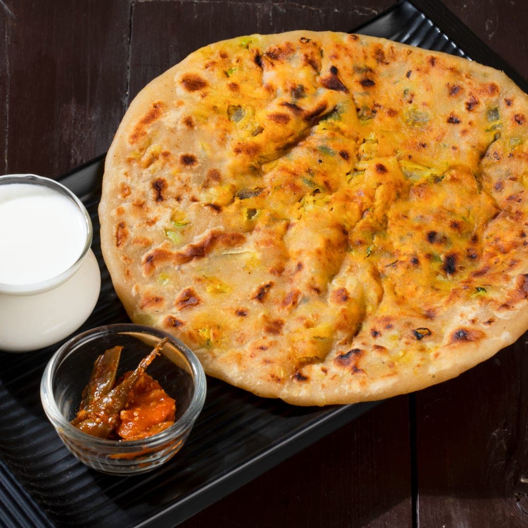 Paneer paratha — stuffed flatbread with spiced cottage cheese, served with butter at IndiaWaale
